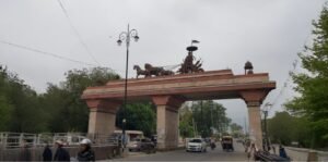 Entrance gateway near Pipli with the Kurukshetra chariot sculpture landmark and traffic passing below, representing the location for students searching for JEE Coaching Near Pipli.