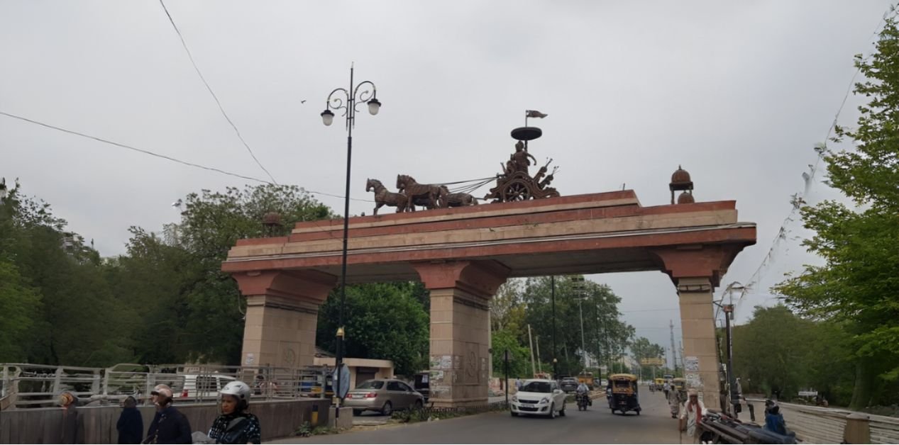 Entrance gateway near Pipli with the Kurukshetra chariot sculpture landmark and traffic passing below, representing the location for students searching for JEE Coaching Near Pipli.